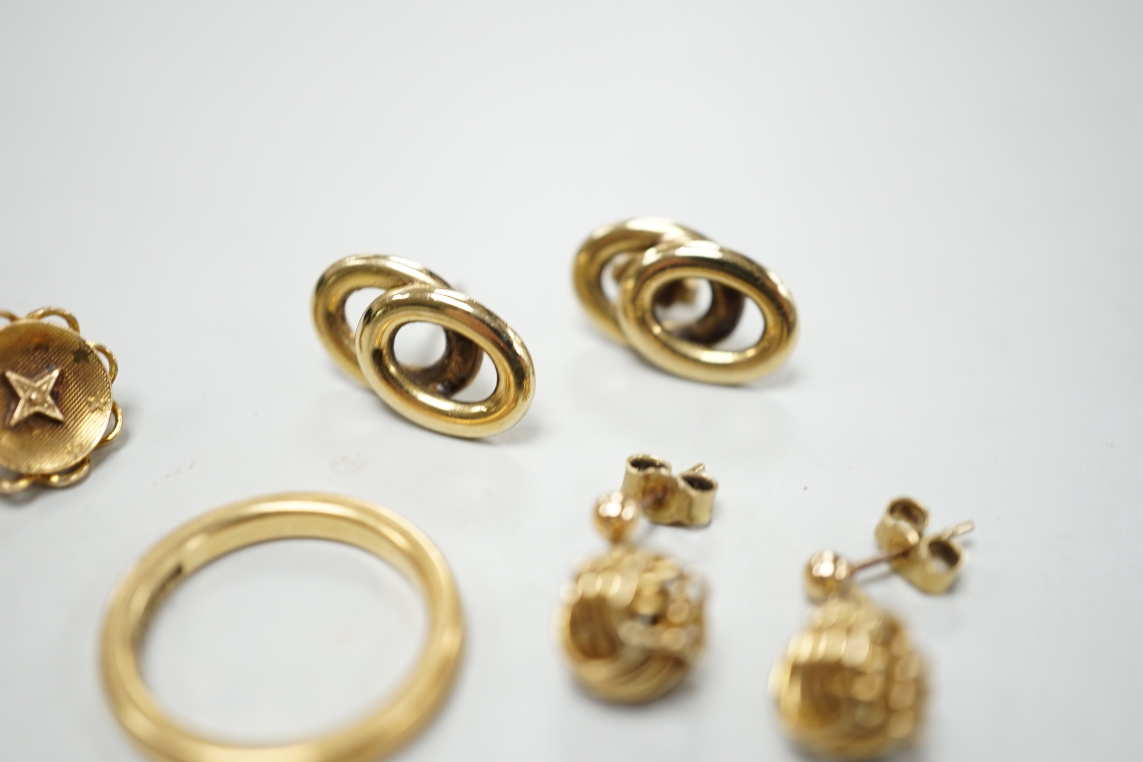 An 18ct gold wedding band, size L/M, 5.2 grams and three pairs of yellow metal earrings.